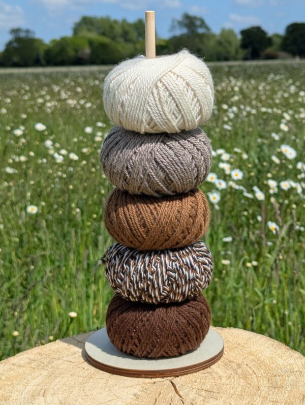 a tower of 50g balls of alpaca yarn in natural colours