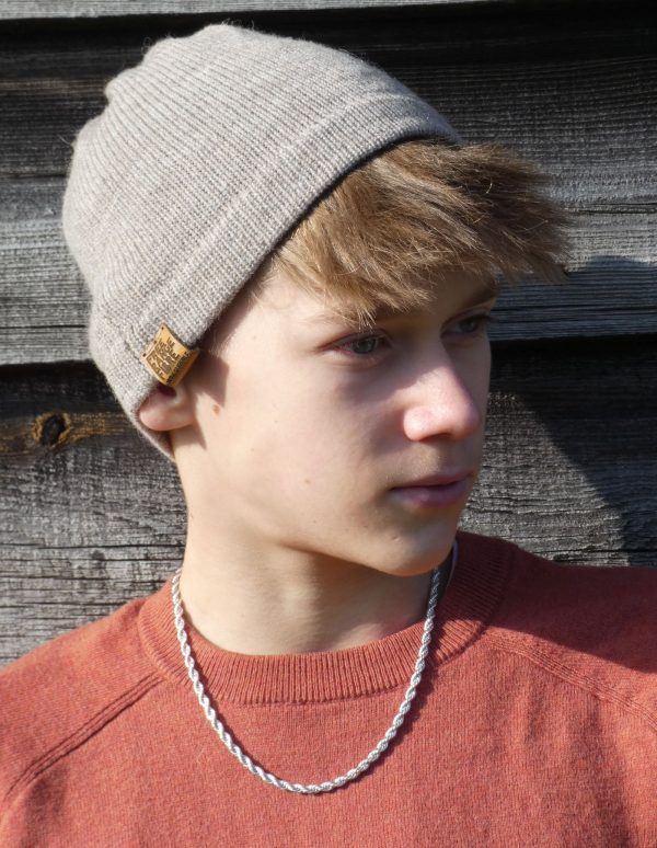 boy wearing a light grey wool hat and orange jumper