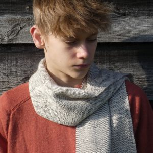 brown and white scarf worn by a boy with an orange jumper