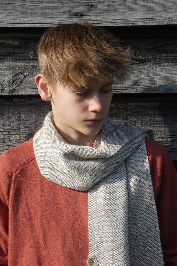 brown and white scarf worn by a boy with an orange jumper