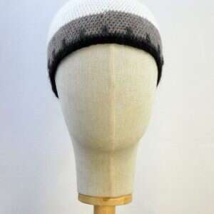 white, grey anmd black beanie hat displayed on a shop display head
