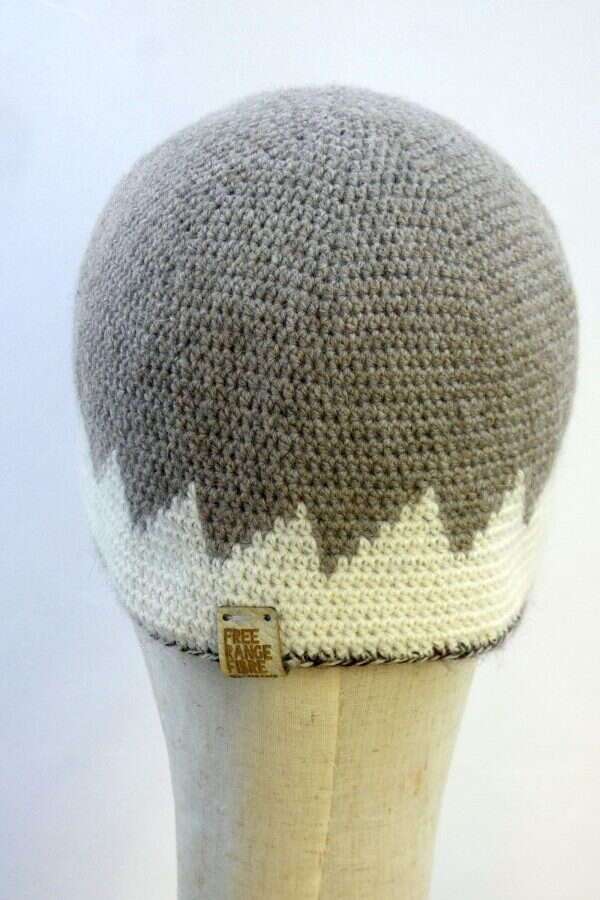 the back of a grey and white beanie hat displayed on a shop display head