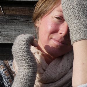 woman wearing light grey wrist warmers in Shetland wool