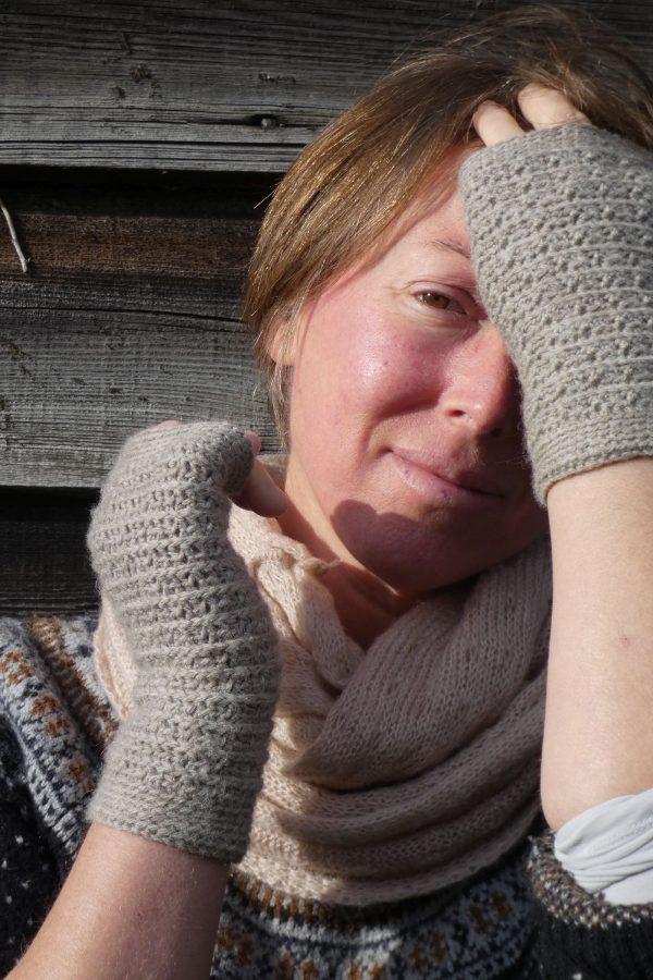 woman wearing light grey wrist warmers in Shetland wool