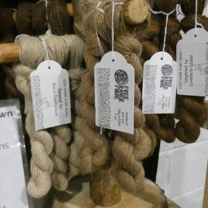 selection of brown alpaca yarn skeins displayed on a stand