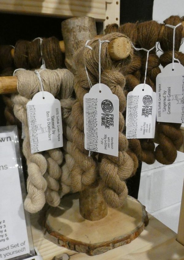 selection of brown alpaca yarn skeins displayed on a stand