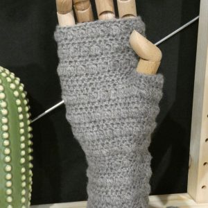 mid grey wrist warmers made from shetland yarn displayed on a wooden hand