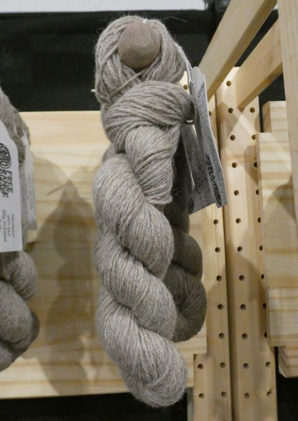light grey shetland wool skein hanging on wooden display