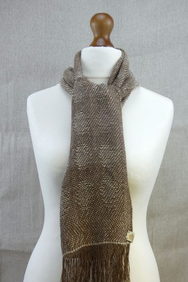 woven suri alpaca scarf with dot detail tied at neck on dress dummy