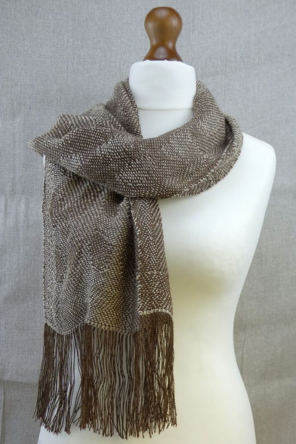 woven suri alpaca scarf with dot detail loosely draped on dress dummy