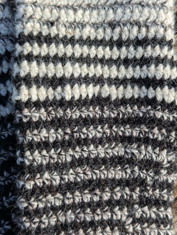 close up of black white and curlew striped alpaca glove