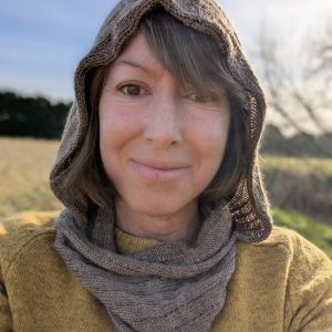 lady in yellow jumper wearing a brown alpaca snood hood