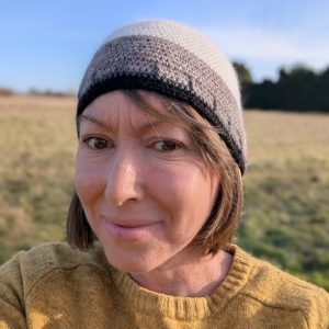 lady wearing a yellow jumper and a white black and grey alpaca beanie hat