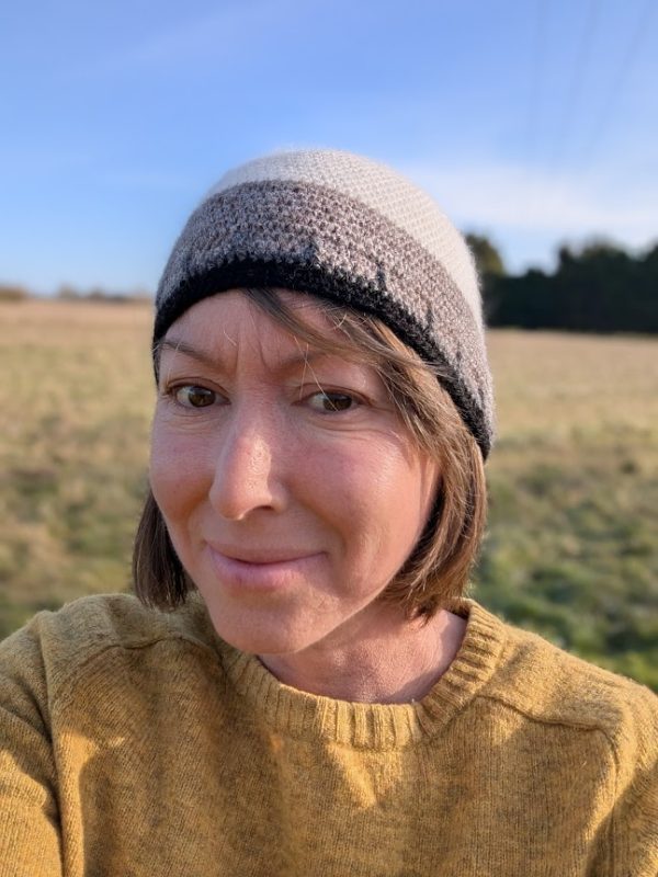 lady wearing a yellow jumper and a white black and grey alpaca beanie hat