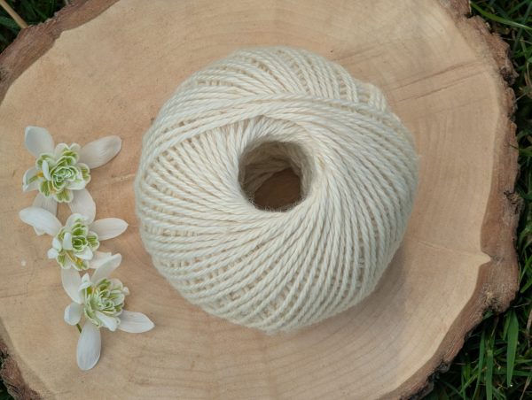 50g ball of alpaca yarn in a soft white limestone colour