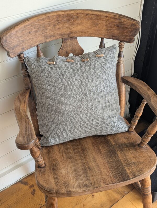 reverse of woollen crochet cushion