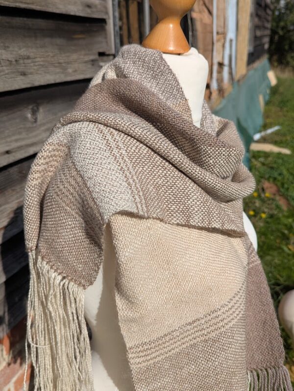 side view of woven alpaca scarf in neutral colours