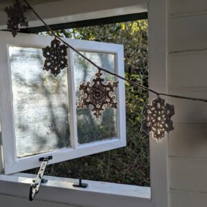 snowflake bunting in a silver colour at the window of a shepherds hut